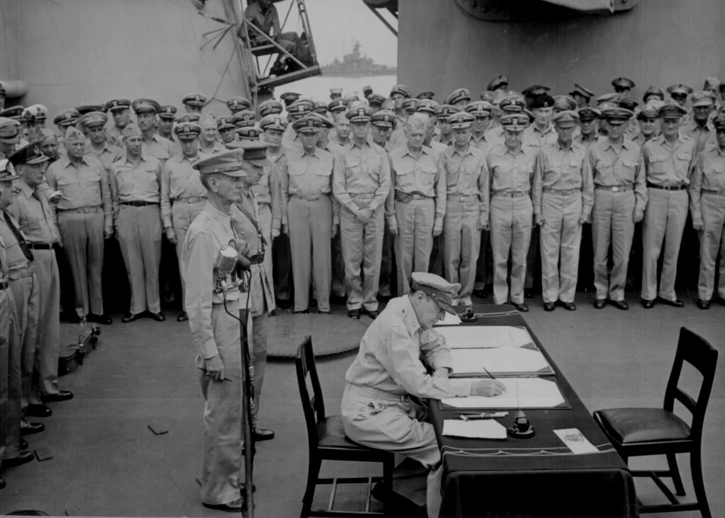 Douglas MacArthur 以最高盟軍司令官身分在 USS Missouri 上接受日本投降;後方可見其他盟軍代表。