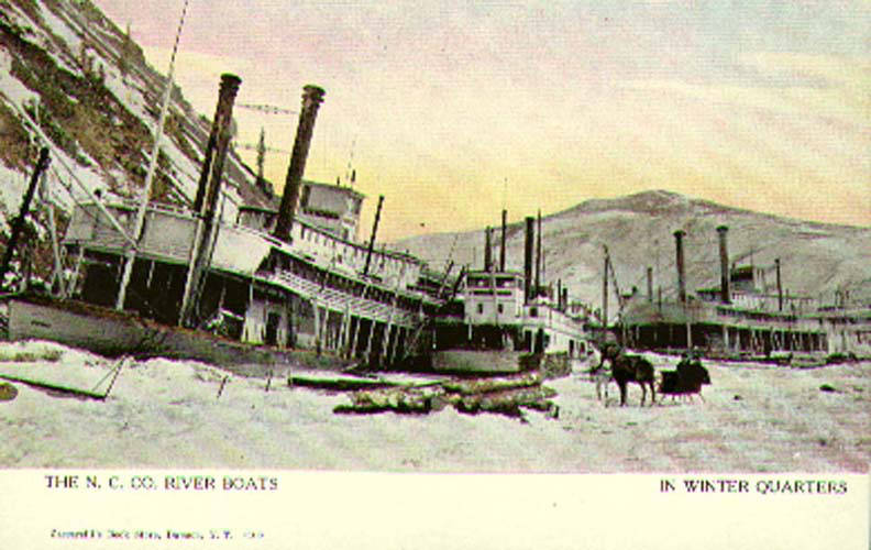 Postcard depicting the Northern Commercial Company steamboats in winter quarters at Steamboat Slough opposite the mouth of the (MEED 177)